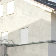 Ansicht einer durch Heckenlauerspinnen bzw. Mauerspinnen verunreinigten Hausfassade